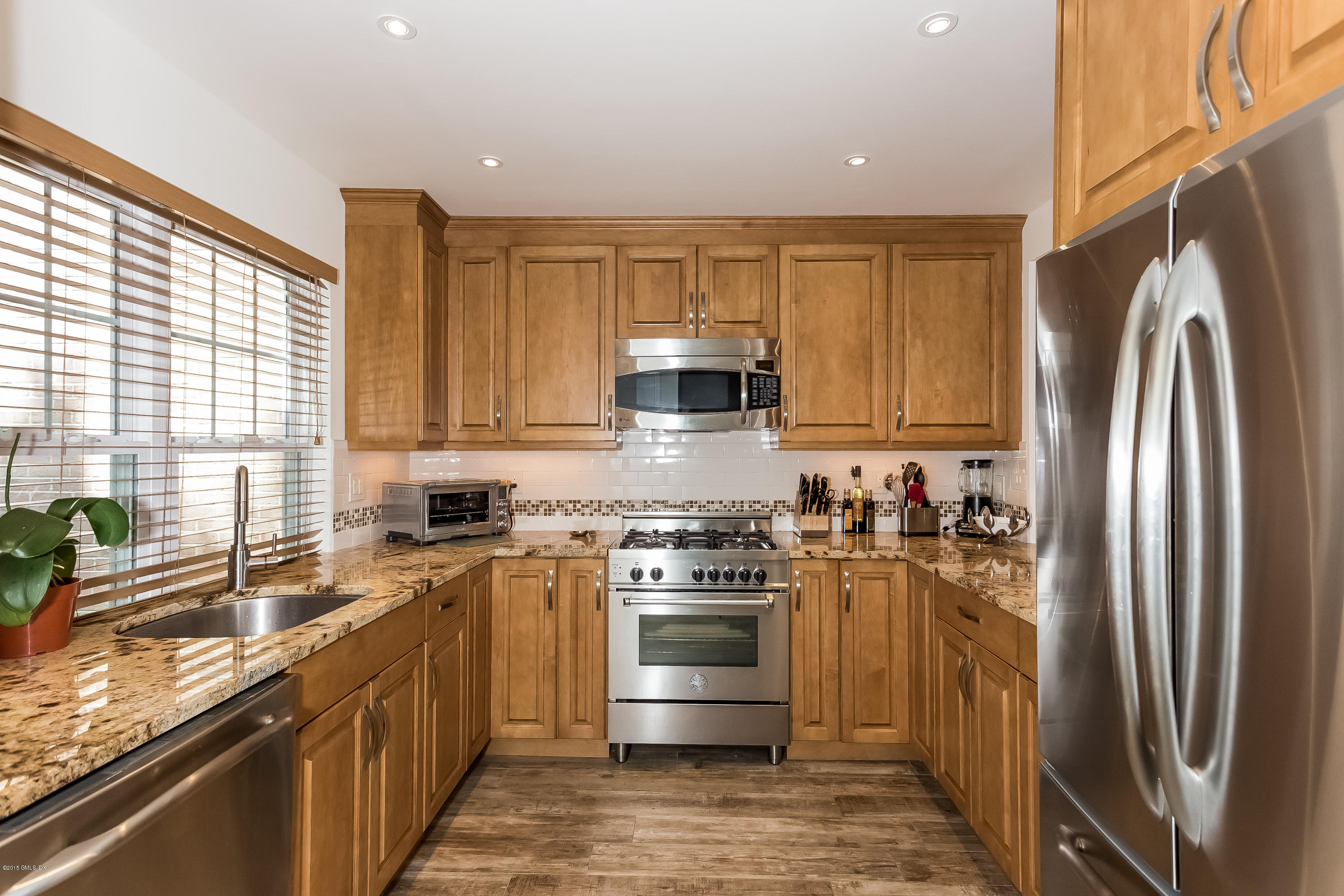 100 Strickland Road, Unit 9 Cos Cob, CT 06807 - Photo 7 of 21 a kitchen with stainless steel appliances granite countertop a stove a refrigerator and a sink