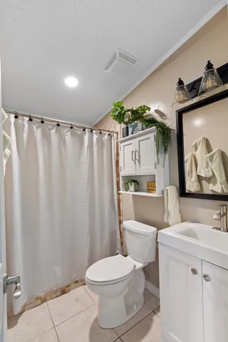 a bathroom with a toilet sink and shower curtain