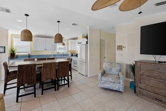 a kitchen with refrigerator and chairs