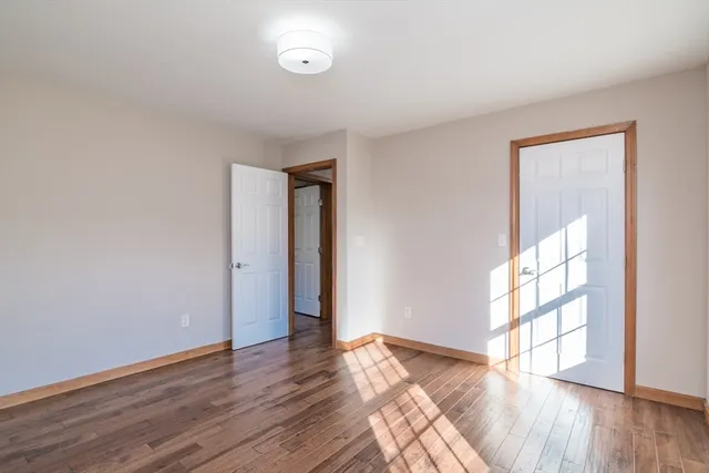 a view of a room with a wooden floor and a ceiling fan