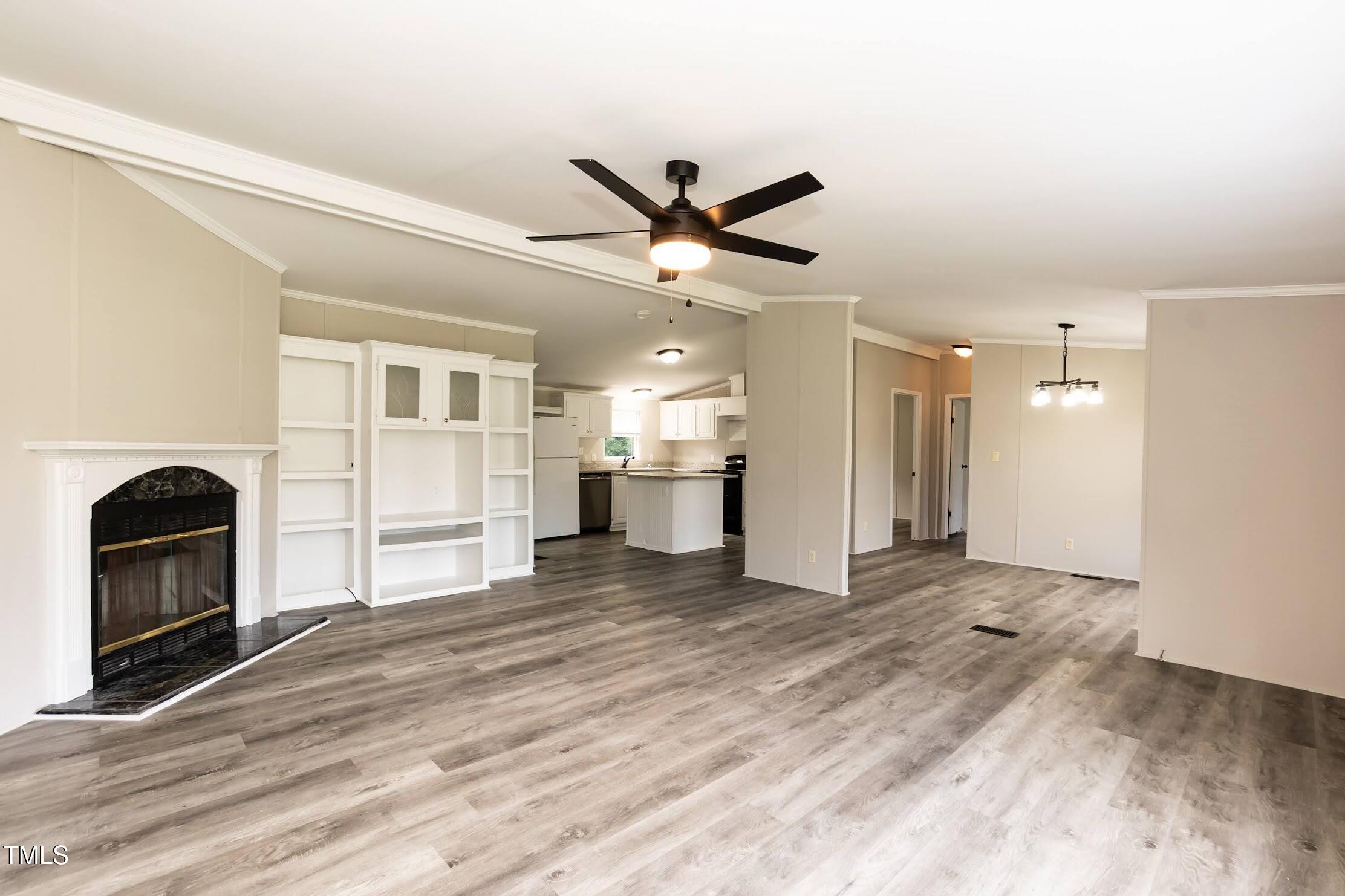 40 Beaver Run Road Spring Hope, NC 27882 - Photo 12 of 28 a view of a livingroom with a kitchen space with wooden floor and a ceiling fan