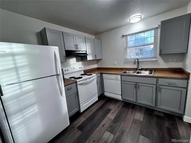 a kitchen with white cabinets white appliances and sink