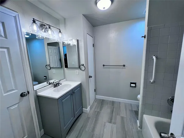 a bathroom with a sink a toilet a mirror and shower