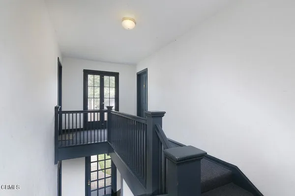 a view of staircase with railing and a window