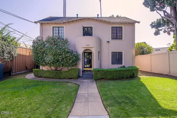 a front view of a house with a garden and plants