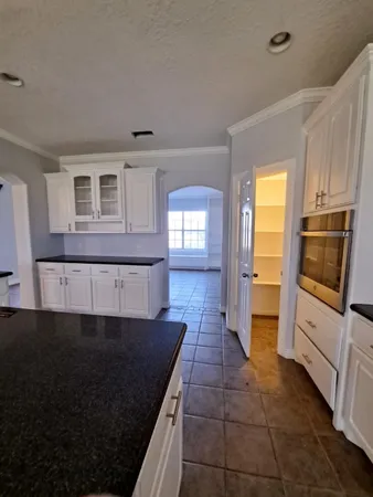 a kitchen with granite countertop a stove a sink and a microwave
