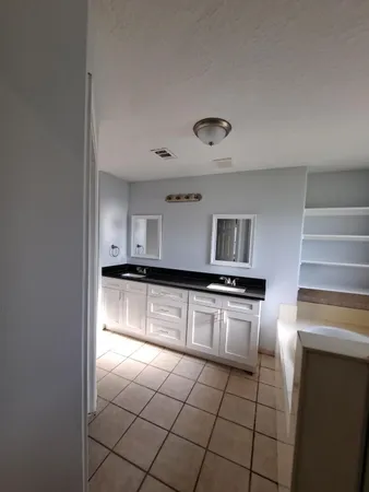a kitchen with granite countertop a stove a sink and a refrigerator