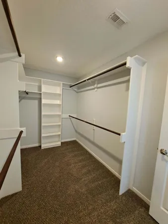 a view of walk in closet with empty racks