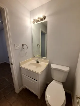 a bathroom with a toilet sink and mirror