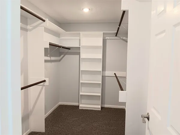 a view of walk in closet with empty racks