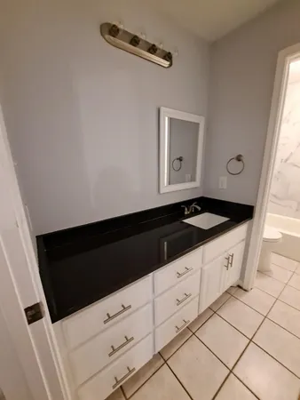 a kitchen with granite countertop white cabinets and black appliances