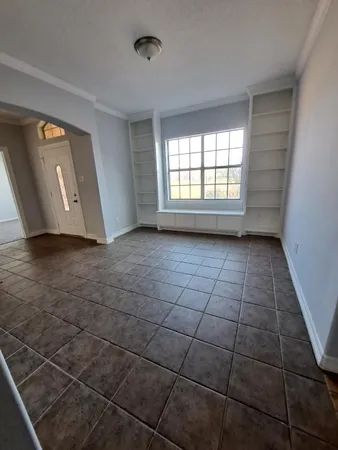 a view of a livingroom with an empty space and a window