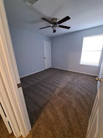 a view of a livingroom with a ceiling fan and window