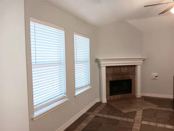 a view of an empty room with a window and fireplace