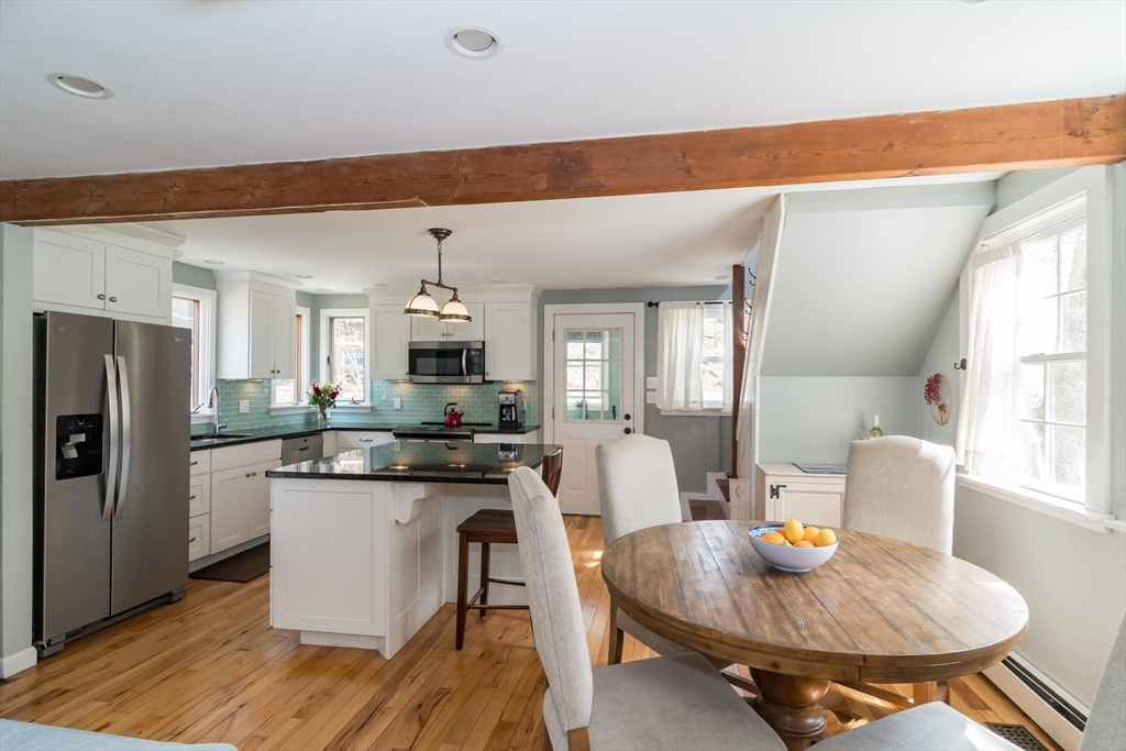 8 Meeting House Hill Road Dover, MA 02030 - Photo 4 of 22 a kitchen with stainless steel appliances kitchen island granite countertop a table chairs and a refrigerator