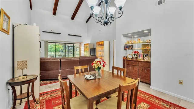 a view of a dining room with furniture a chandelier and wooden floor