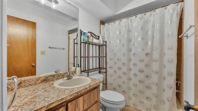 a bathroom with a granite countertop sink toilet and shower
