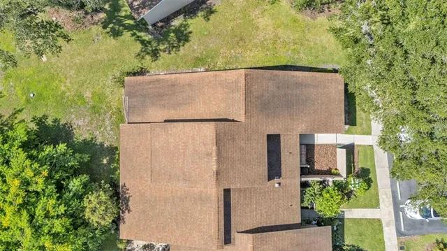aerial view of a house with a yard and large tree