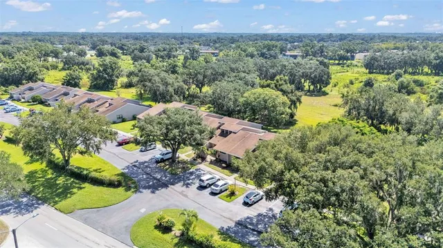 an aerial view of residential houses with outdoor space and trees