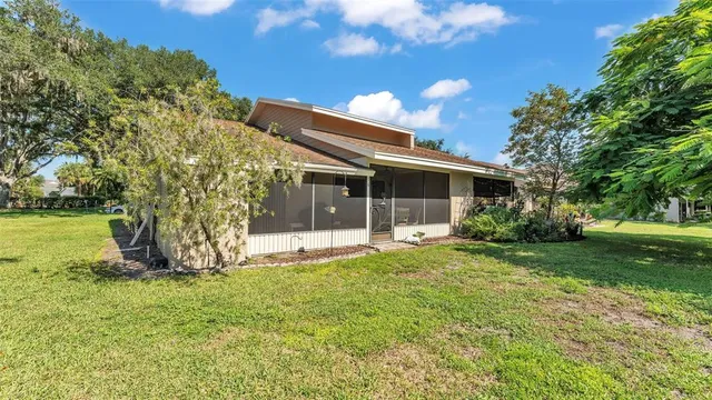 a view of a house with backyard and a tree