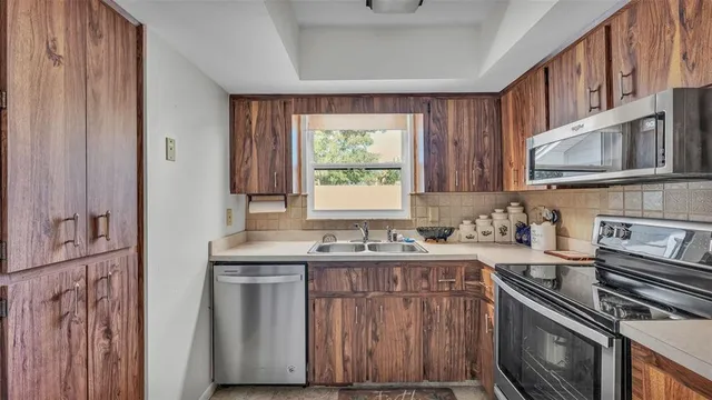 a kitchen with stainless steel appliances granite countertop a stove a sink and a microwave