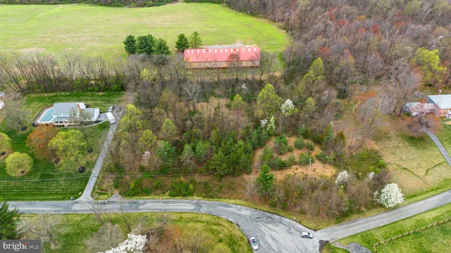 an aerial view of residential houses with outdoor space and trees