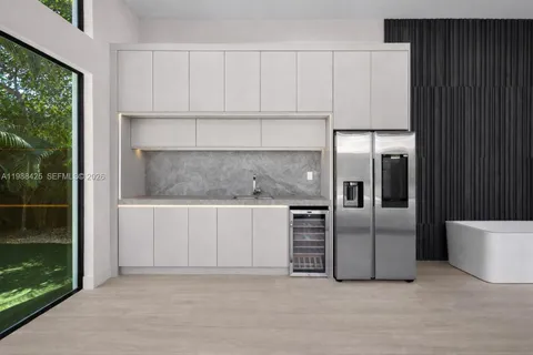 a kitchen with granite countertop a refrigerator and a sink