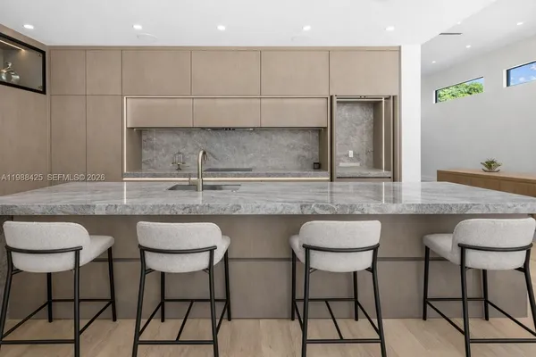 a kitchen with stainless steel appliances granite countertop a table chairs stove and sink