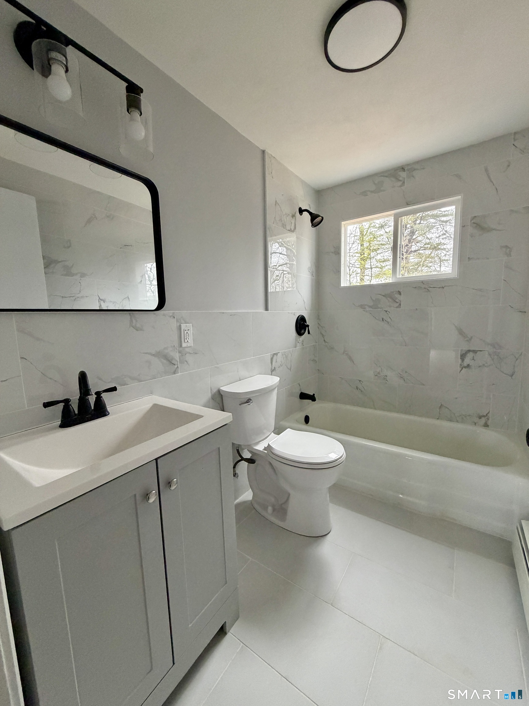 164 Sycamore Street, Unit 1R Bristol, CT 06010 - Photo 7 of 10 a bathroom with a toilet sink a mirror and bathtub