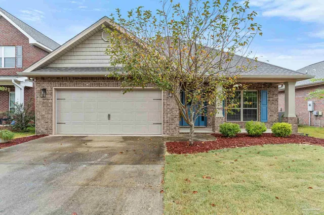 a view of a house with a yard and potted plants