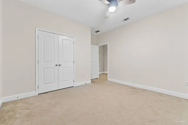 an empty room with a ceiling fan and window
