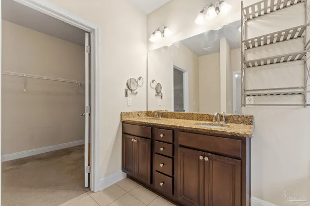 a bathroom with a granite countertop sink a mirror and a shower