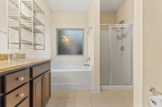 a bathroom with a granite countertop sink a mirror and a shower