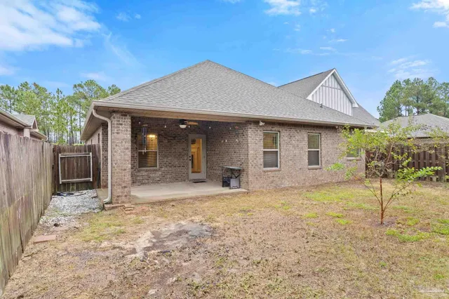 a view of a house with backyard and a tree