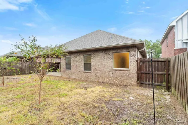 a backyard of a house with table and chairs