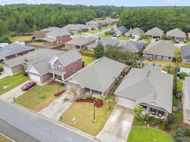 an aerial view of residential houses with outdoor space and parking