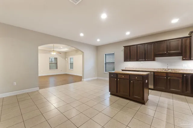a large kitchen with stainless steel appliances granite countertop a sink and cabinets