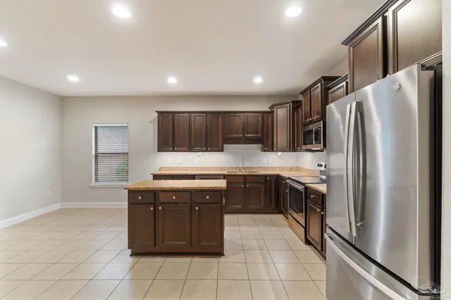 a kitchen with stainless steel appliances granite countertop a refrigerator and a stove