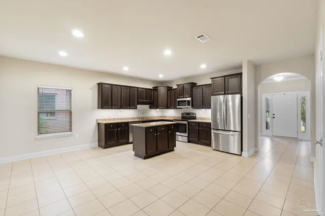 a kitchen with stainless steel appliances a refrigerator and a stove top oven