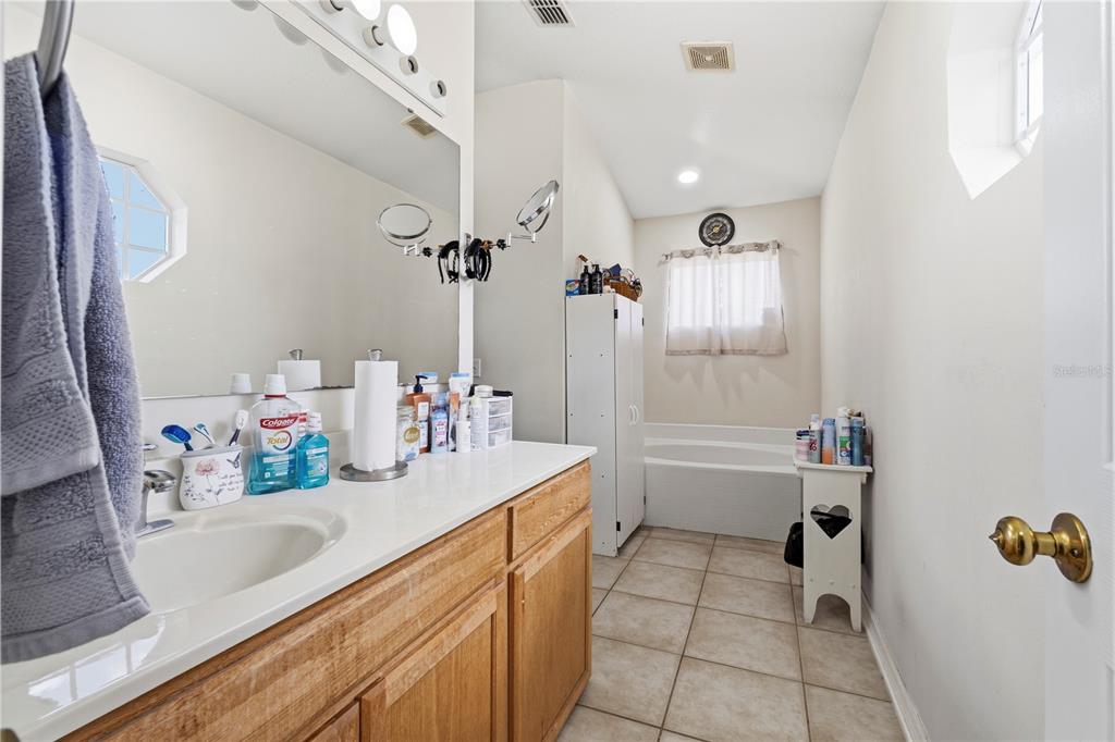 2881 Southwest 142nd Lane Ocala, FL 34473 - Photo 27 of 60 a bathroom with a sink vanity granite tub shower and a mirror