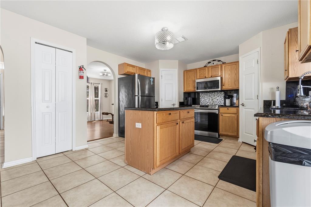 2881 Southwest 142nd Lane Ocala, FL 34473 - Photo 44 of 60 a kitchen with stainless steel appliances granite countertop a stove top oven a sink a counter top space and cabinets