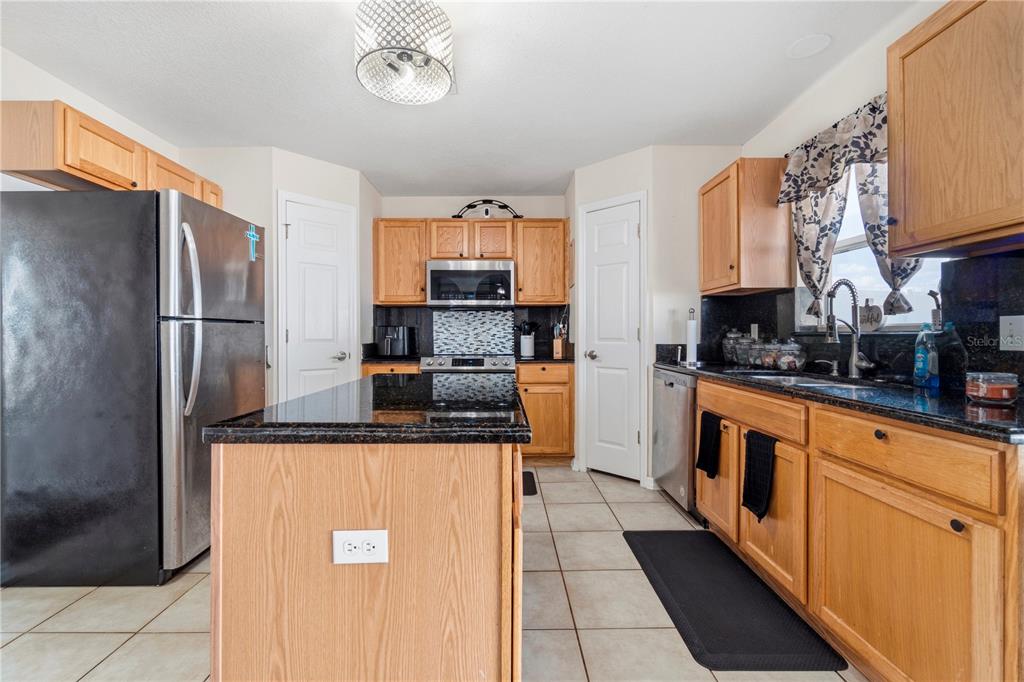2881 Southwest 142nd Lane Ocala, FL 34473 - Photo 49 of 60 a kitchen with stainless steel appliances granite countertop a refrigerator a stove and a sink
