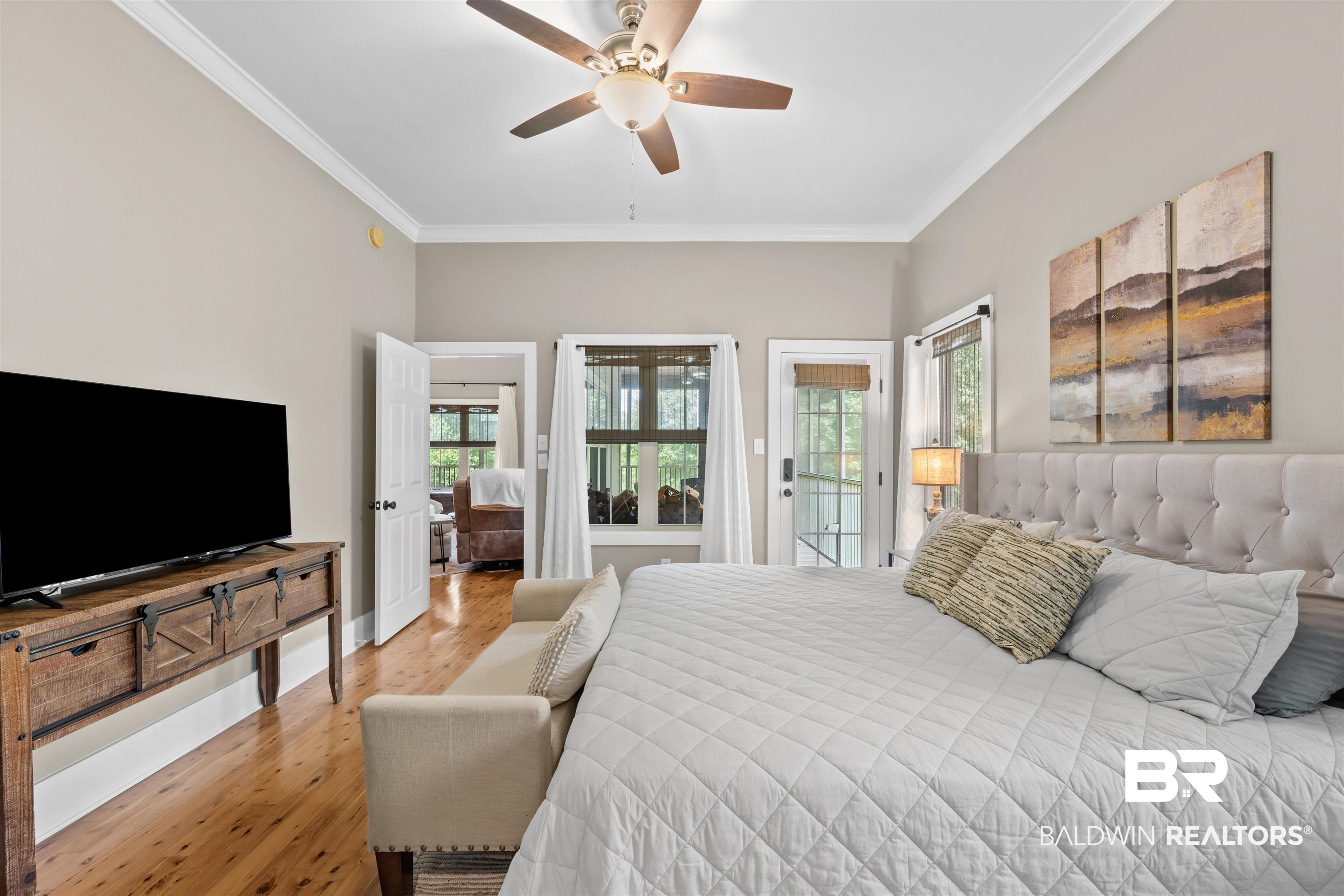 32700 Steelwood Ridge Road, Unit D Loxley, AL 36551 - Photo 13 of 41 Spacious room featuring wood-finish flooring, crown molding, a ceiling fan, and outdoor access via a glass-paneled door