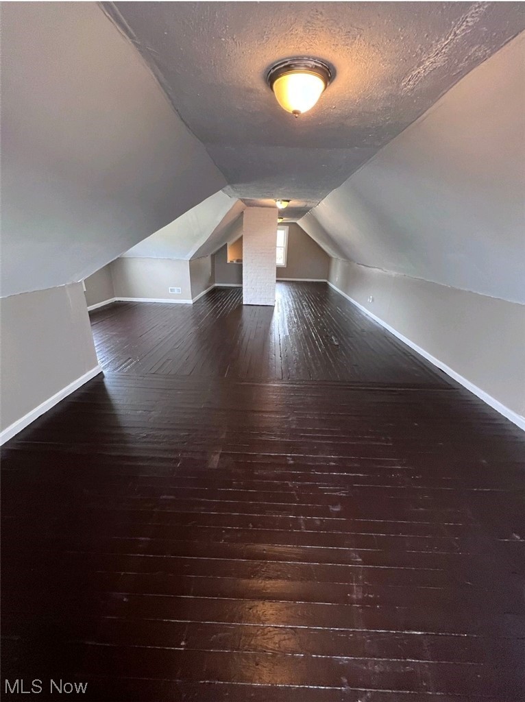 875-877 Paxton Road Cleveland, OH 44108 - Photo 14 of 18 Bonus room with vaulted ceiling, dark hardwood / wood-style floors, and a textured ceiling