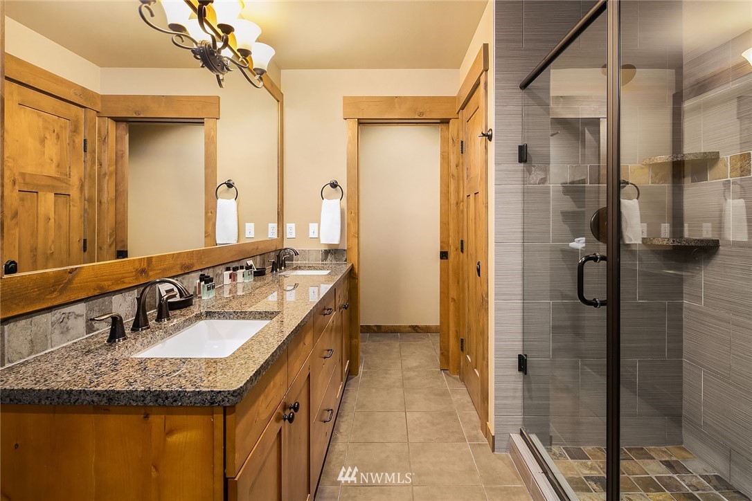 3770 Suncadia Trail, Unit 110 Cle Elum, WA 98922 - Photo 12 of 21 a bathroom with a granite countertop sink a mirror and shower