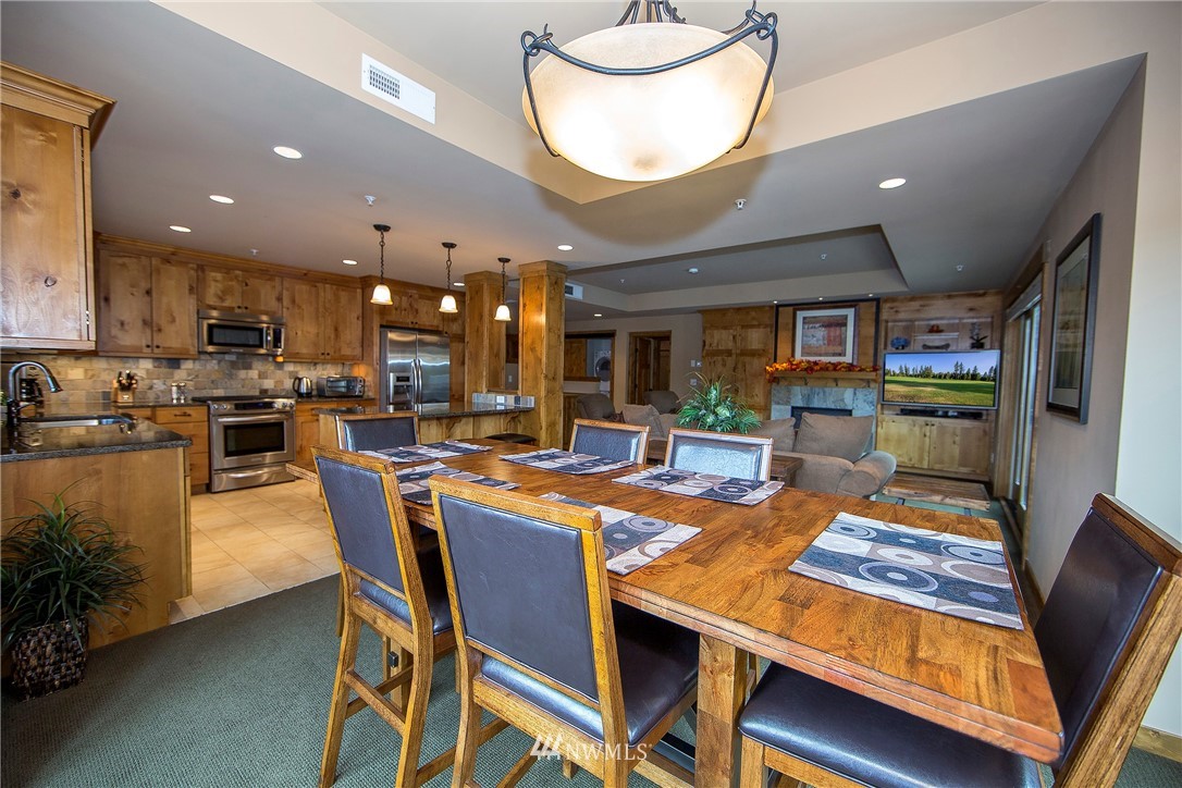 3770 Suncadia Trail, Unit 110 Cle Elum, WA 98922 - Photo 3 of 21 a dining room with stainless steel appliances kitchen island granite countertop a table chairs and a stove