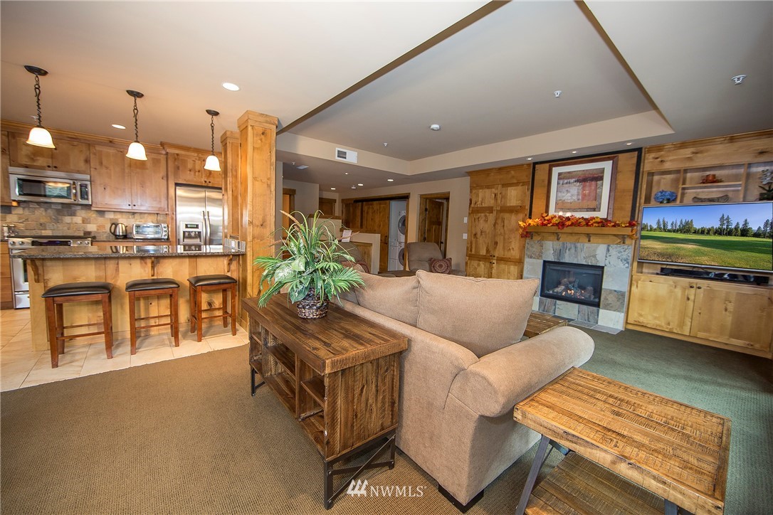 3770 Suncadia Trail, Unit 110 Cle Elum, WA 98922 - Photo 6 of 21 a living room with furniture a fireplace and a kitchen view