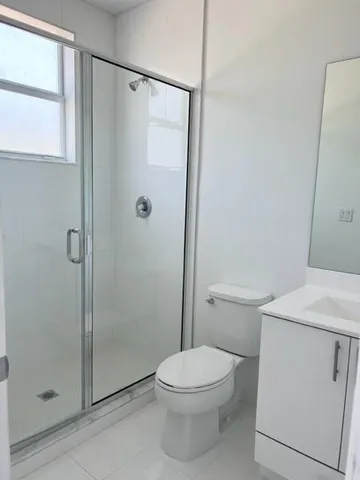 a bathroom with a shower a toilet and a sink
