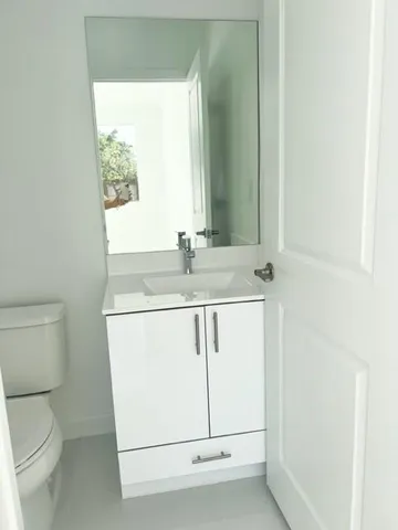 a bathroom with a sink a toilet and a mirror