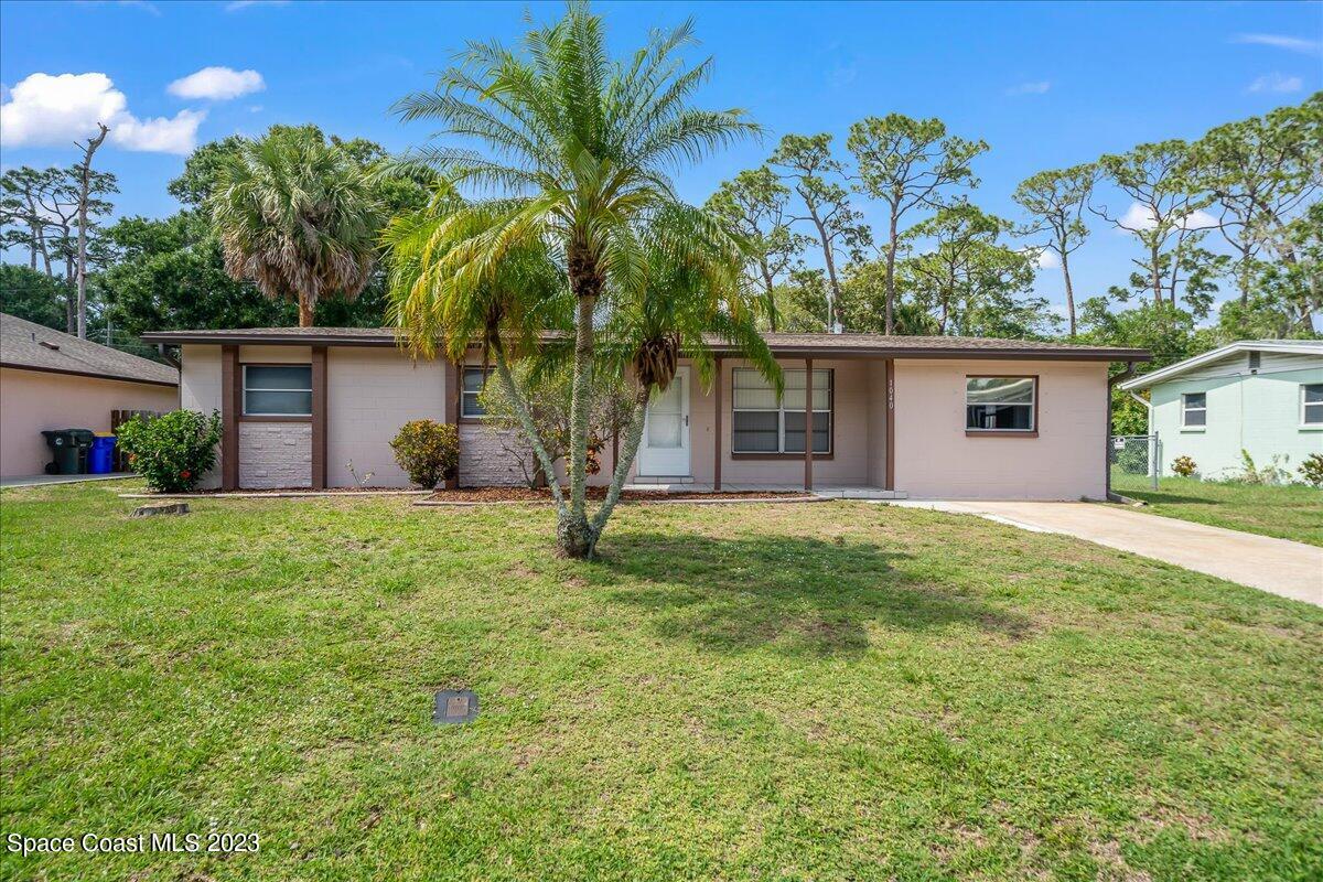 1040 Bernice Road Rockledge, FL 32955 - Photo 1 of 24 a backyard of a house with potted plants and palm trees